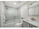 Bright bathroom featuring a shower-tub combo with tile surround, a gray vanity, and a lighted mirror at 718 White Pine Tree Rd # 80, Venice, FL 34285