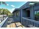 View of a blue condo from the wood balcony with view of the parking lot and palm trees at 7214 Cloister Dr # 7214, Sarasota, FL 34231