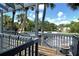 Wood balcony overlooking palm trees, parking lot, and green lawn at 7214 Cloister Dr # 7214, Sarasota, FL 34231