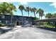 Inviting exterior of a blue condo building with palm trees and covered parking at 7214 Cloister Dr # 7214, Sarasota, FL 34231