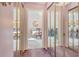 Hallway with mirrored closet doors reflecting the dining and living rooms at 7214 Cloister Dr # 7214, Sarasota, FL 34231