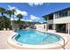 Enjoy the community pool with a lounge area and shade with tropical palm trees at 7214 Cloister Dr # 7214, Sarasota, FL 34231