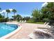 Inviting pool with lounge chairs, complemented by mature landscaping and a sunny sky at 7214 Cloister Dr # 7214, Sarasota, FL 34231