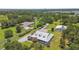Estate with a large metal roof home, surrounding outbuildings and lush greenery at 7264 Spencer Parrish Rd, Parrish, FL 34219