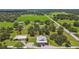 Picturesque aerial view of a home, outbuilding with solar panels, and expansive green space at 7264 Spencer Parrish Rd, Parrish, FL 34219