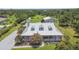 Aerial view of a home with a metal roof and dormer windows, surrounded by lush greenery at 7264 Spencer Parrish Rd, Parrish, FL 34219