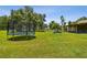 Large grassy backyard with trampoline and playground equipment providing plenty of space for recreation at 7264 Spencer Parrish Rd, Parrish, FL 34219