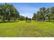 Spacious backyard with mature trees, trampoline, and playground, perfect for outdoor fun and relaxation at 7264 Spencer Parrish Rd, Parrish, FL 34219