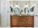 Bathroom with double sink vanity, granite counters, round mirrors, sconces, and tile floors at 7264 Spencer Parrish Rd, Parrish, FL 34219