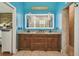 Bathroom showcasing double vanity with decorative mirror and a tile shower at 7264 Spencer Parrish Rd, Parrish, FL 34219