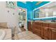 Bright bathroom with double vanity, a tile shower, and beach-themed decorations at 7264 Spencer Parrish Rd, Parrish, FL 34219