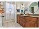 Bathroom boasts a double vanity with wood cabinets, granite counters, and a window providing natural light at 7264 Spencer Parrish Rd, Parrish, FL 34219