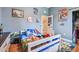 Bedroom with blue walls, bed with colorful sheets, and a dresser at 7264 Spencer Parrish Rd, Parrish, FL 34219