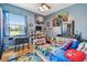 Playful bedroom with blue walls, a vibrant bedspread, desk and storage shelving at 7264 Spencer Parrish Rd, Parrish, FL 34219