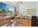 Cozy bedroom with light green walls, hardwood floors, window with curtains, shelving, desk and chair at 7264 Spencer Parrish Rd, Parrish, FL 34219