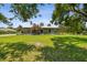 A cozy single-story home with a charming front porch, set against a blue sky and lush green lawn at 7264 Spencer Parrish Rd, Parrish, FL 34219