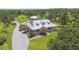 An aerial view of a charming single-story home with a metal roof, surrounded by lush greenery and landscaping at 7264 Spencer Parrish Rd, Parrish, FL 34219