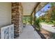 Covered front porch features stone accents, wooden beams, and ample space for seating with views of the expansive yard at 7264 Spencer Parrish Rd, Parrish, FL 34219