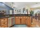 Kitchen island featuring a stainless steel dishwasher, wood cabinets, and granite countertops at 7264 Spencer Parrish Rd, Parrish, FL 34219