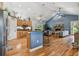 Open floor plan showcasing the kitchen with breakfast bar, living room with fireplace, and vaulted ceilings at 7264 Spencer Parrish Rd, Parrish, FL 34219