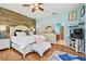 Cozy main bedroom featuring a wooden accent wall, ensuite bath, and plenty of natural light at 7264 Spencer Parrish Rd, Parrish, FL 34219