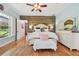 Inviting main bedroom with a wooden accent wall, bright windows, and hardwood floors at 7264 Spencer Parrish Rd, Parrish, FL 34219