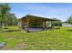 Covered patio with seating and outdoor grill provides a comfortable space for outdoor gatherings and relaxation at 7264 Spencer Parrish Rd, Parrish, FL 34219