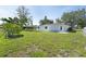 Spacious backyard with lush green grass, mature trees, and a charming fence at 7308 17Th W Ave, Bradenton, FL 34209