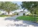 Well-maintained home boasts a lush green lawn, mature trees, and a welcoming driveway at 7308 17Th W Ave, Bradenton, FL 34209
