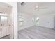 Bright main bedroom featuring gray wood-look floors, white walls, natural lighting, and an ensuite bathroom at 7308 17Th W Ave, Bradenton, FL 34209