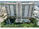 Stunning high-rise building overlooking a peaceful pond with a fountain and pool at 750 N Tamiami Trl # 1005, Sarasota, FL 34236
