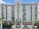 Luxury high-rise condo with a fountain, pool, and palms against a blue sky at 750 N Tamiami Trl # 1005, Sarasota, FL 34236