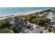 Aerial view showcases beachside recreation building, beach access paths, and palm trees near the shore at 813 Oak Pond Dr, Osprey, FL 34229