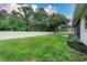 Spacious backyard featuring a well-maintained lawn, a white fence and beautiful trees at 813 Oak Pond Dr, Osprey, FL 34229