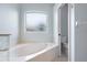 Bright bathroom showcasing a soaking tub under a window and toilet area in an alcove at 813 Oak Pond Dr, Osprey, FL 34229