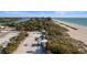 High angle captures beach access paths, beachside park and lush tropical vegetation leading to the pristine beach at 813 Oak Pond Dr, Osprey, FL 34229