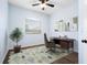 Bedroom features a ceiling fan and a window with hard wood floors and modern office furnishings at 813 Oak Pond Dr, Osprey, FL 34229