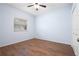 Empty bedroom with a ceiling fan, hard wood floors, and a window providing natural light at 813 Oak Pond Dr, Osprey, FL 34229