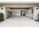 Garage with concrete floors, open door, metal racks for storage, and an exterior light at 813 Oak Pond Dr, Osprey, FL 34229