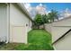 A quaint side yard with green grass and a privacy fence at 813 Oak Pond Dr, Osprey, FL 34229