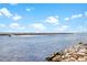 Scenic water view featuring a boat gliding along calm waters with a rocky shoreline in the foreground at 813 Oak Pond Dr, Osprey, FL 34229