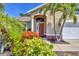 Close up front view featuring mature landscaping, a red door and a two-car garage at 815 Greenview Dr, Apollo Beach, FL 33572