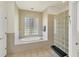 Stylish main bathroom featuring a soaking tub, glass block details, and serene ambiance, ideal for relaxation at 815 Greenview Dr, Apollo Beach, FL 33572