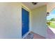 Close-up of a vibrant blue front door with textured walls and a covered porch at 8321 43Rd Ave W, Bradenton, FL 34209