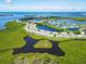 Aerial view of community with bay views, winding streets, water features, and tropical landscaping at 840 Audubon Dr, Bradenton, FL 34209