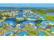 Aerial view of waterfront community with blue roofs, lush landscaping, and beautiful bay views at 840 Audubon Dr, Bradenton, FL 34209