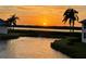 Beautiful sunset view from waterfront property with palm trees, a serene landscape, and tranquil waters at 840 Audubon Dr, Bradenton, FL 34209