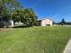 Expansive backyard with green grass and a partial view of the home's exterior at 8409 Trionfo Ave, North Port, FL 34287