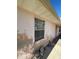 Exterior side view of the home with peeling paint and a sidewalk leading to the front door at 8409 Trionfo Ave, North Port, FL 34287