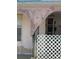 View of the front side of the home and showing peeling paint, a white lattice fence, and front windows at 8409 Trionfo Ave, North Port, FL 34287